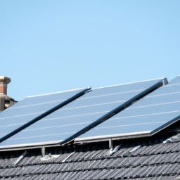 A rooftop solar panel installation with a clear blue sky background.