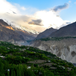A serene view of the Hunza Valley with lush green terraced fields and snow-capped mountains in the background.